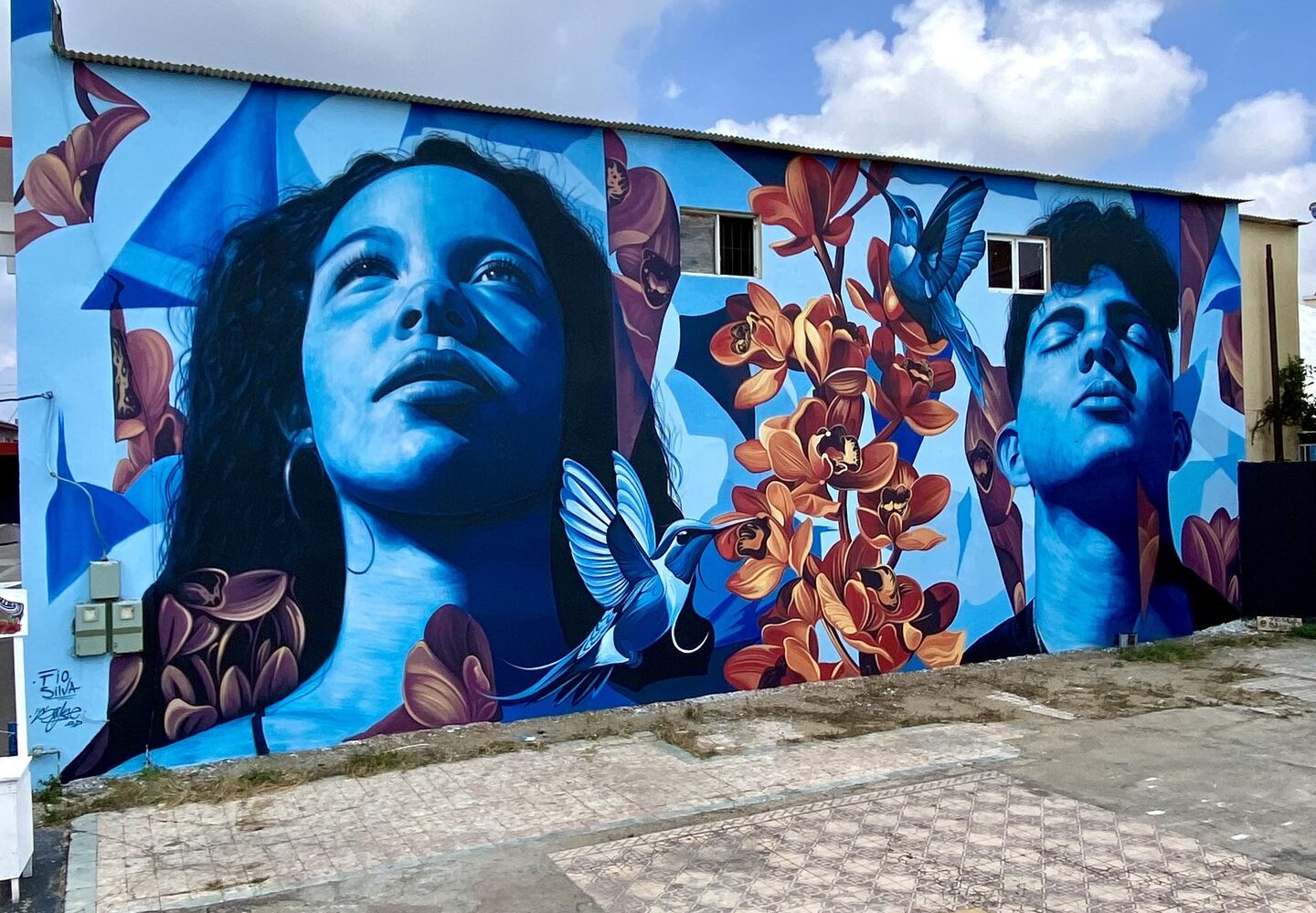 Mural Lo de aqui by Fio Silva and Sake Ink, San Nicolas, Aruba, 2025, seen along the wall.