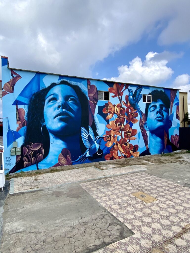 Mural Lo de aqui by Fio Silva and Sake Ink, San Nicolas, Aruba, 2025, seen along the wall.